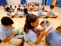 00023955A ma nb AlmadelMar1stDay  K-4th graders read a book while sitting in the gymnasium as they prepare for morning routine on the first day of school at the Alma del Mar's new school on Belleville Avenue in the north end of New Bedford.   PETER PEREIRA/THE STANDARD-TIMES/SCMG : school, education